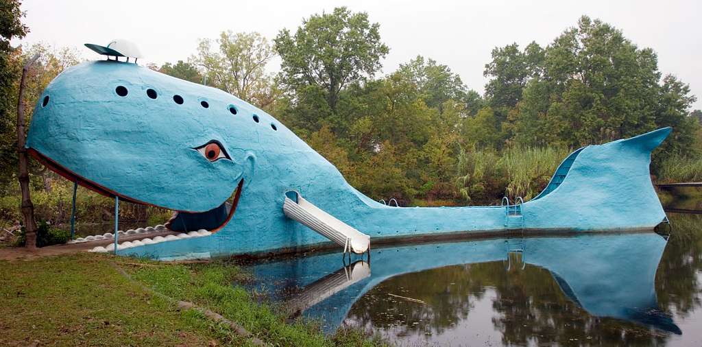 A blue whale shaped sculpture in the water.